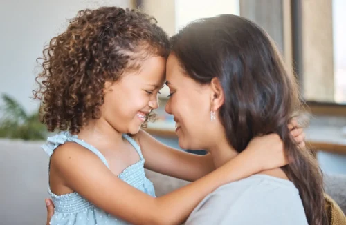 Mom and daughter forehead to forehead smiling at each other