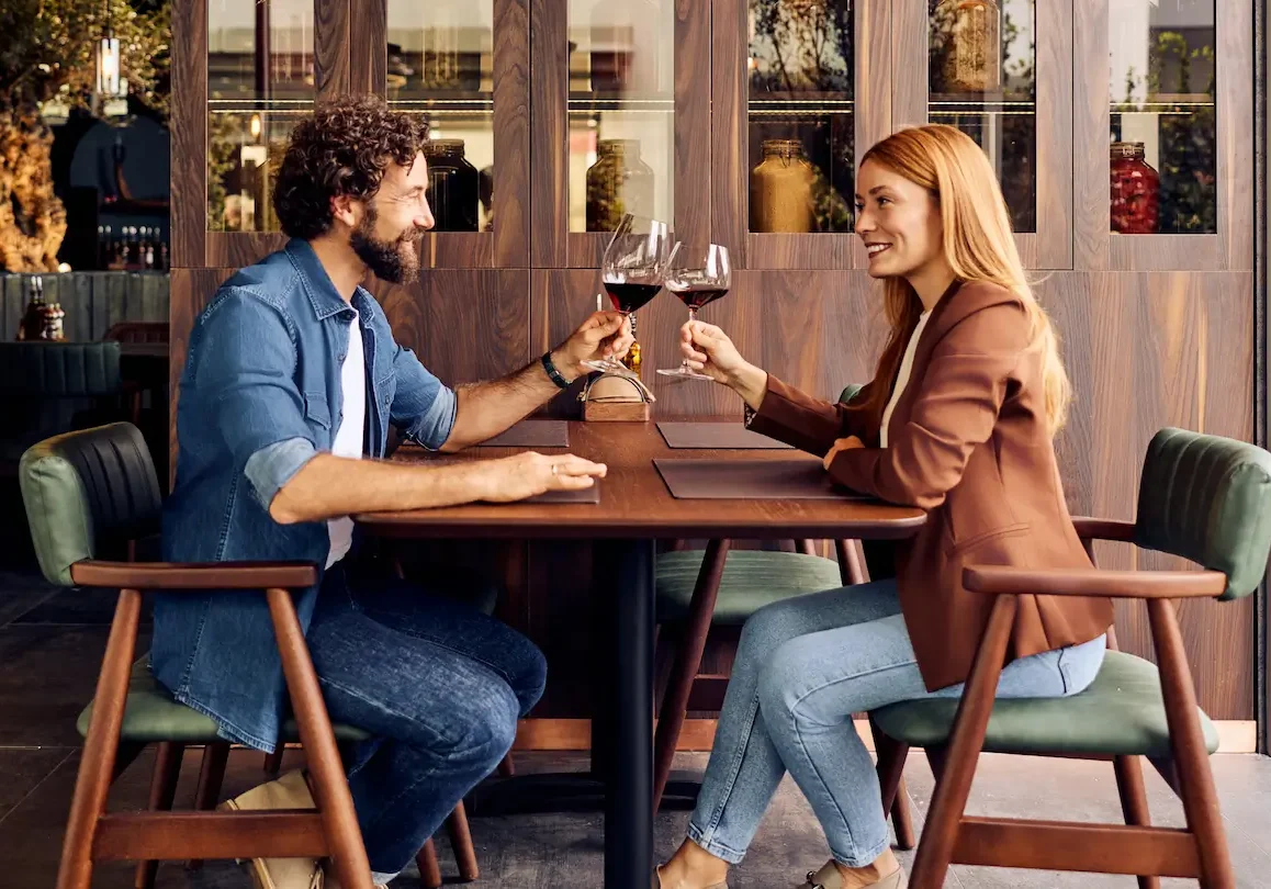 Date night Mother and father sitting at restaurant with glasses of red wine enjoying a date night